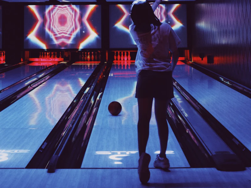 Person bowlar i en neonbelyst bowlinghall